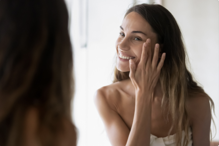 Woman Admiring Clear Skin In The Mirror